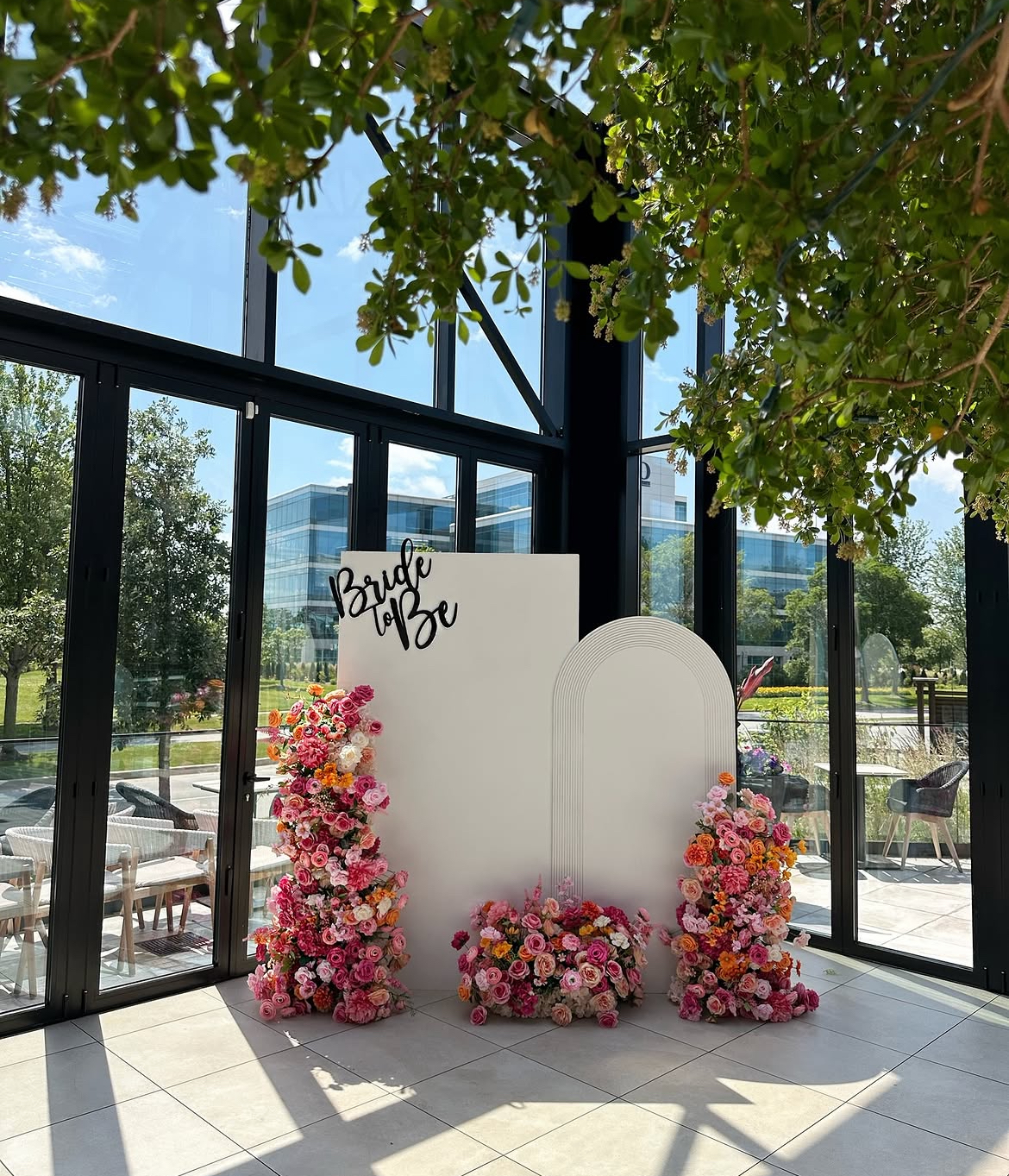 Bridal shower backdrop rental Chicago — Bride to Be white arch backdrop with colorful floral arrangements